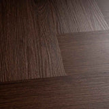 Close-up van Pure Visgraat Brown plak pvc met voelbare houtnerf en visgraatpatroon