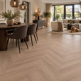 Altessa Visgraat Smoky Plak PVC – sfeerbeeld: eetkamer met donkere stoelen, zithoek op achtergrond