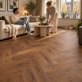 Dunea Visgraat Dark Oak Klik PVC – sfeerbeeld: woonkamer met witte bank, stel en kat