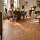 Dunea Visgraat Warm Oak Klik PVC – sfeerbeeld: eethoek met tafel, stel drinkt koffie