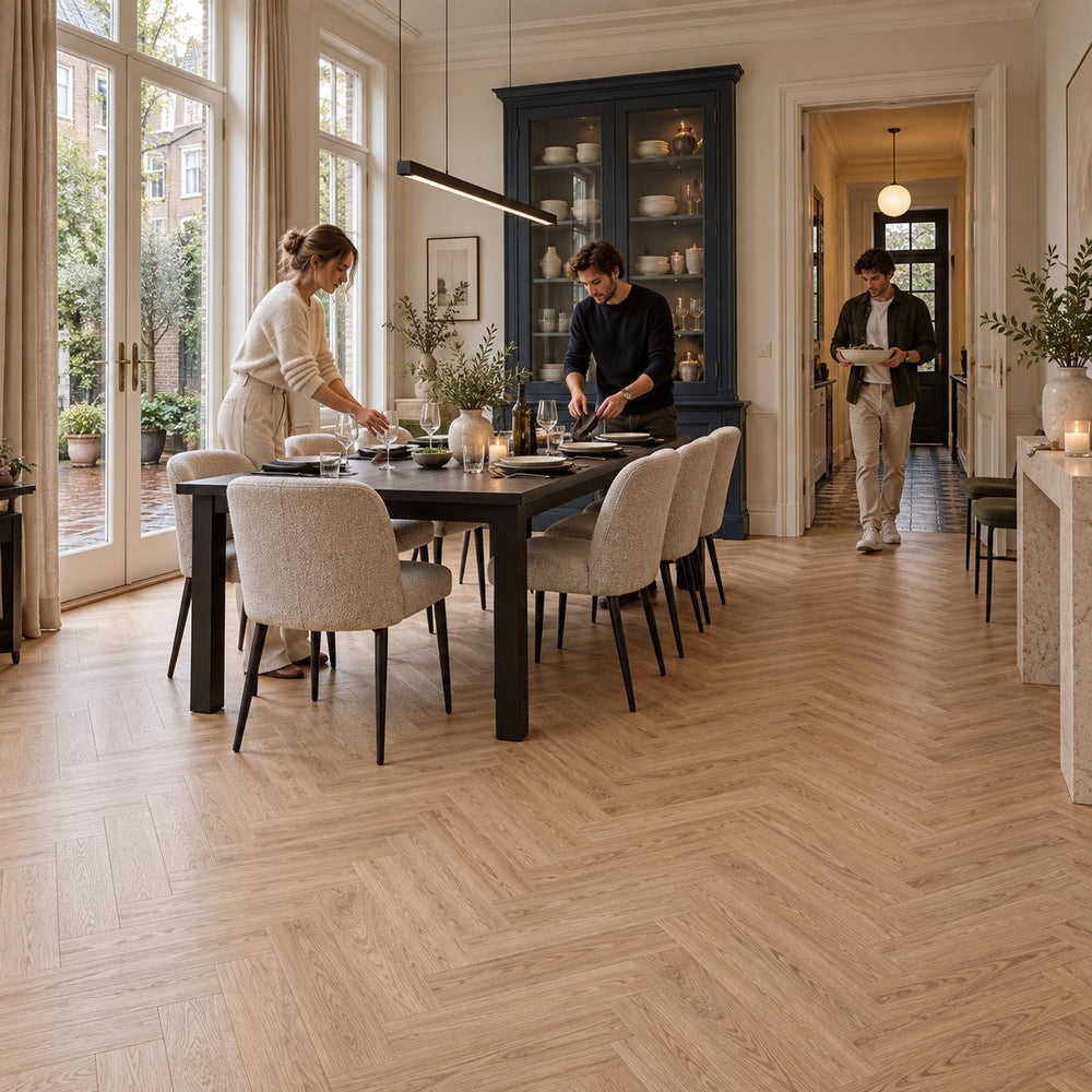 Natura Visgraat Warm Oak Klik PVC – sfeerbeeld: eetkamer met lange zwarte tafel en servieskast, gezin dekt de tafel
