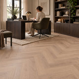 Altessa Visgraat White Wash Smoky Plak PVC – sfeerbeeld: thuiswerkplek met bureau, vrouw aan laptop en boekenkast