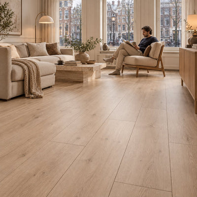Armonia Large Sorento 8mm Extra Breed Laminaat – sfeerbeeld: woonkamer met bank, man leest in fauteuil
