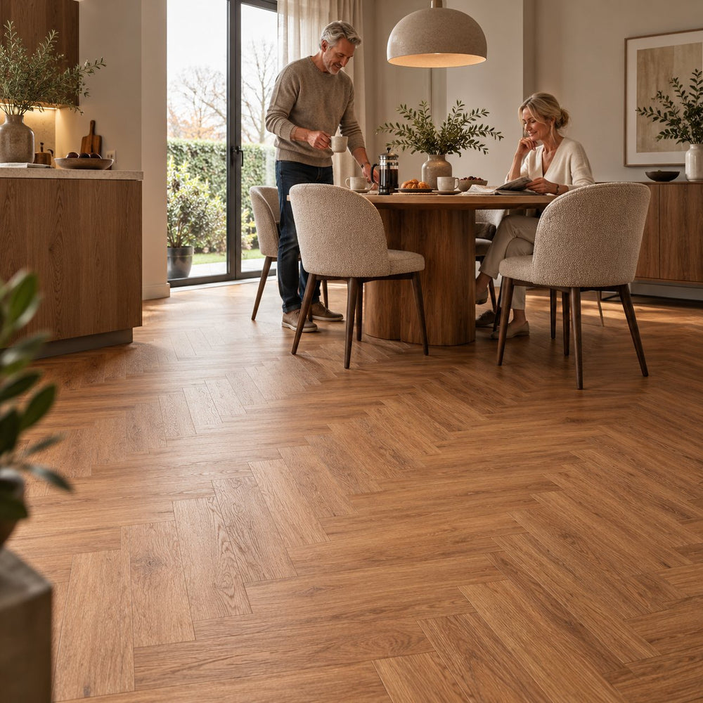 Dunea Visgraat Warm Oak Klik PVC – sfeerbeeld: eethoek met ronde tafel, stel aan tafel